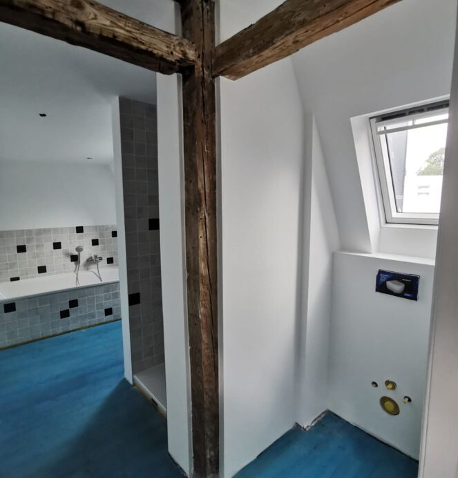 Altbausanierung in Lübeck Altbausanierung in Lübeck mit moderner weißer Wandgestaltung und Holzquerbalken